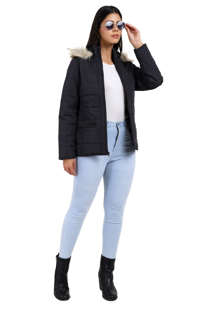 A woman in a standing pose in black shades, wearing Trufit’s dark grey Matte Quilted Jacket with Horizontal Pockets, zip closure, a removable hood and blue jeans, is holding her shades.